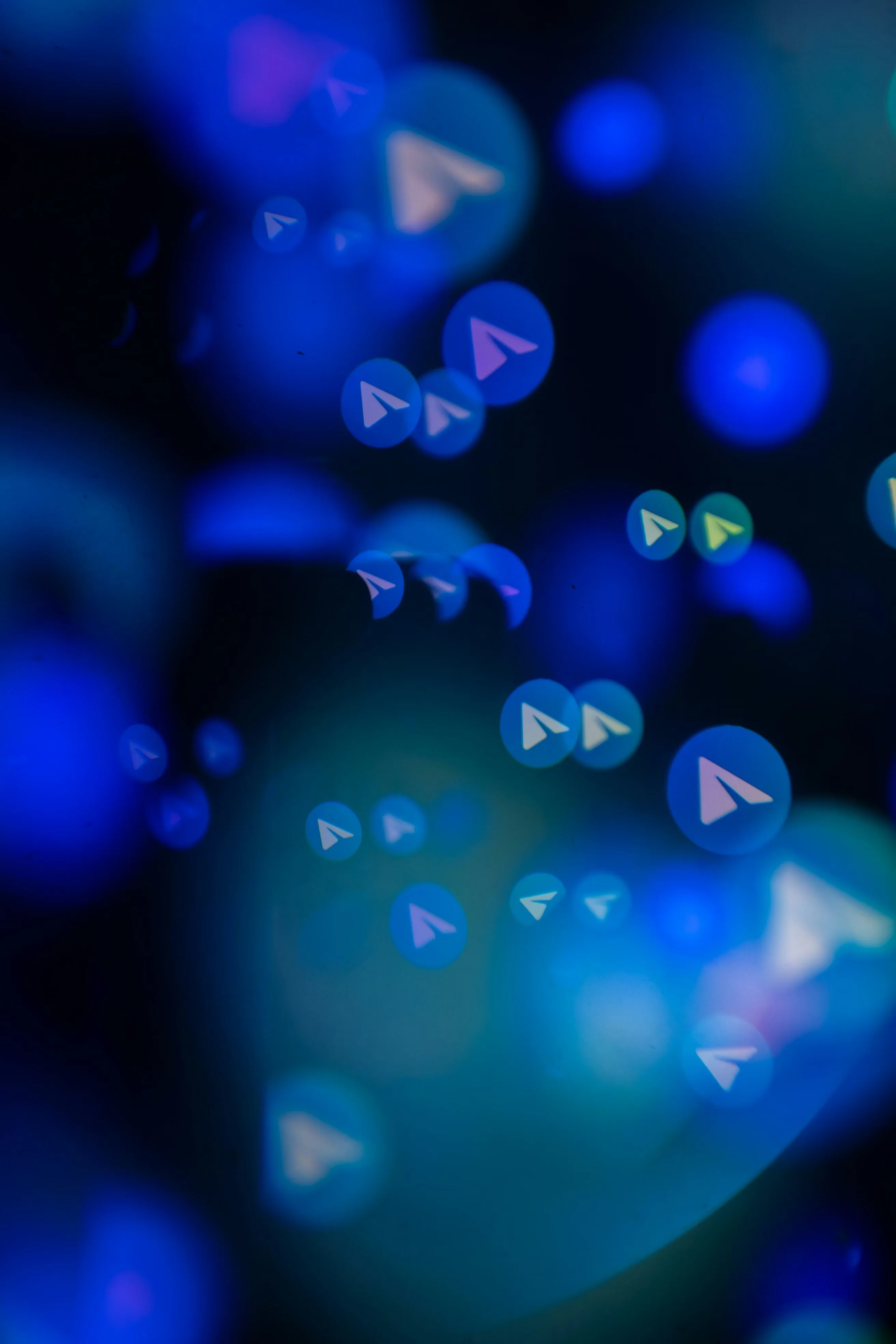 An abstract digital graphic featuring glowing blue bokeh circles and multiple small Telegram paper airplane icons floating against a dark background.